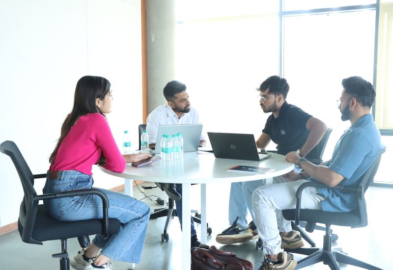 Founder strategy session around a table with laptops